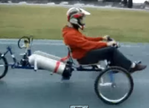 Boy riding a 3 wheel motor bike running on compressed air.