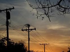 Photo of sun setting with telephone poles